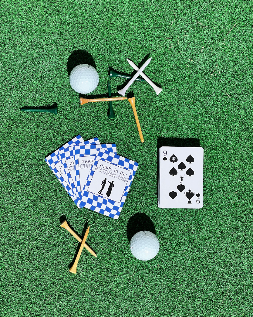 Golf-inspired blue checkered playing cards by Aced It Co., designed for game nights, golf trips, and clubhouse gatherings. on a green turf with golf tees and golf balls