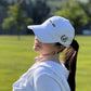 Aced It Co. Golf Is Therapy hat featuring a classic dad hat silhouette and golf-inspired design, modeled by a female golfer on the golf course