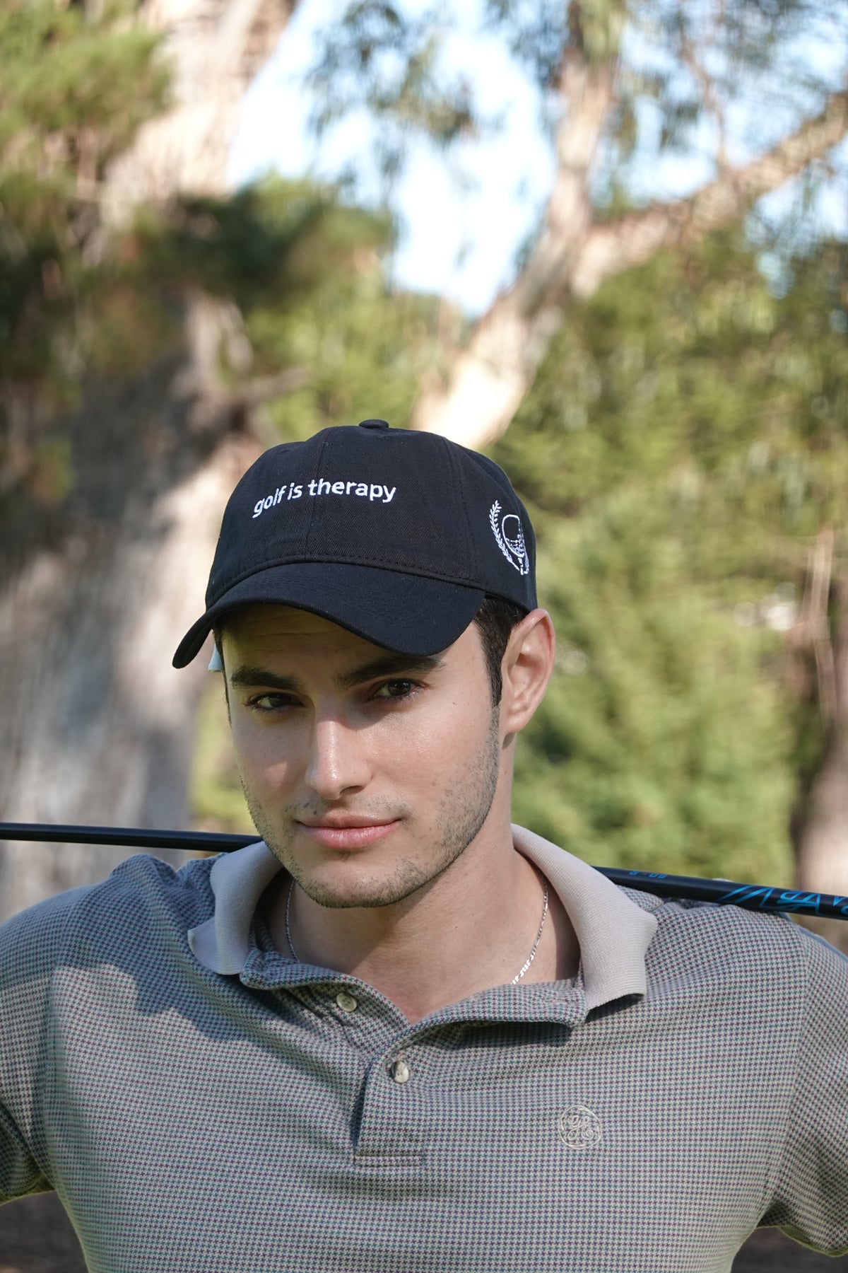 a black Golf Is Therapy embroidered golf hat by Aced It Co., a casual accessory for golf lovers.