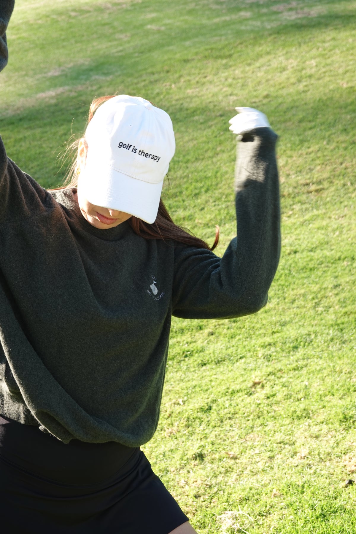 Aced It Co. Golf Is Therapy baseball cap, designed for everyday wear on and off the golf course. modeled by a female golfer