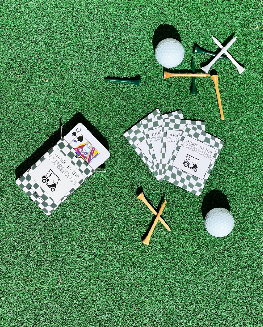 Golf-inspired green checkered playing cards by Aced It Co., designed for game nights, golf trips, and clubhouse gatherings. on a green turf with golf tees and golf balls