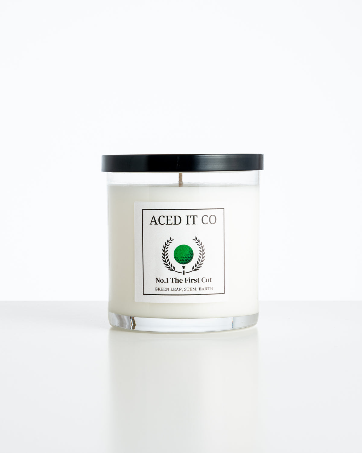 Aced It Co. The First Cut golf-inspired candle in a glass jar, featuring a green golf ball label.